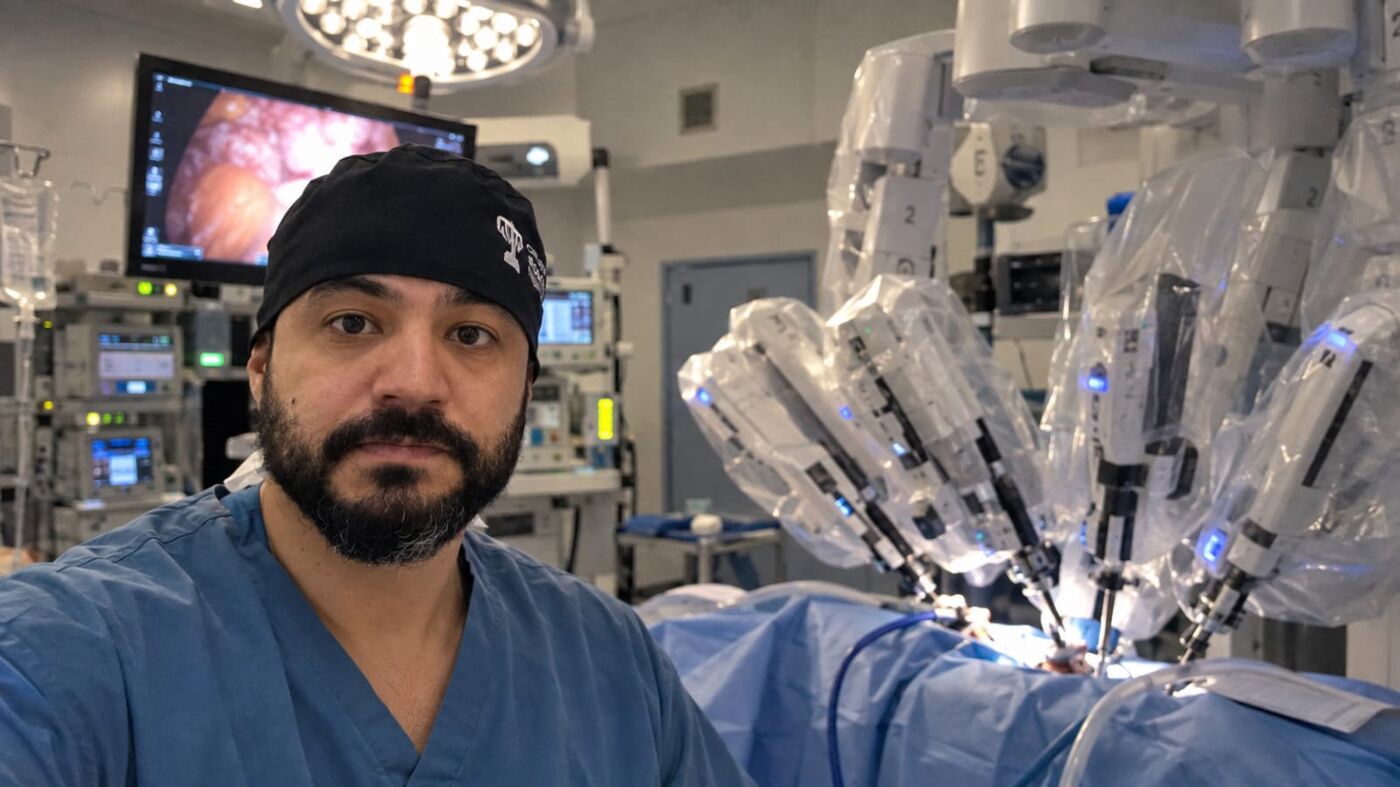 Dr. Alzemir Santos em sala cirúrgica, ao lado da plataforma de cirurgia robótica