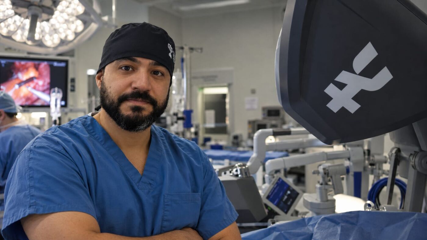 Dr. Alzemir Santos no centro cirúrgico, ao lado do console de cirurgia robótica